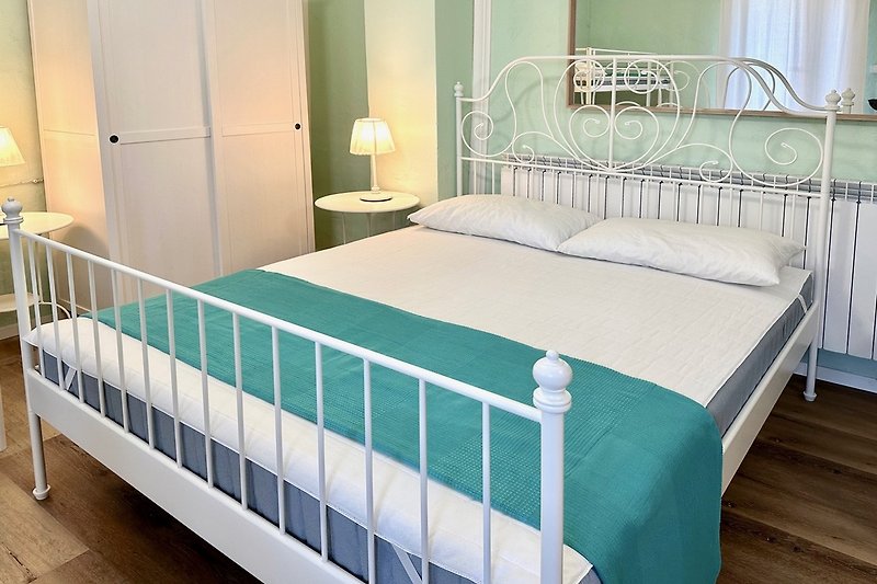 Una confortevole camera da letto con un letto in legno e biancheria di alta qualità.