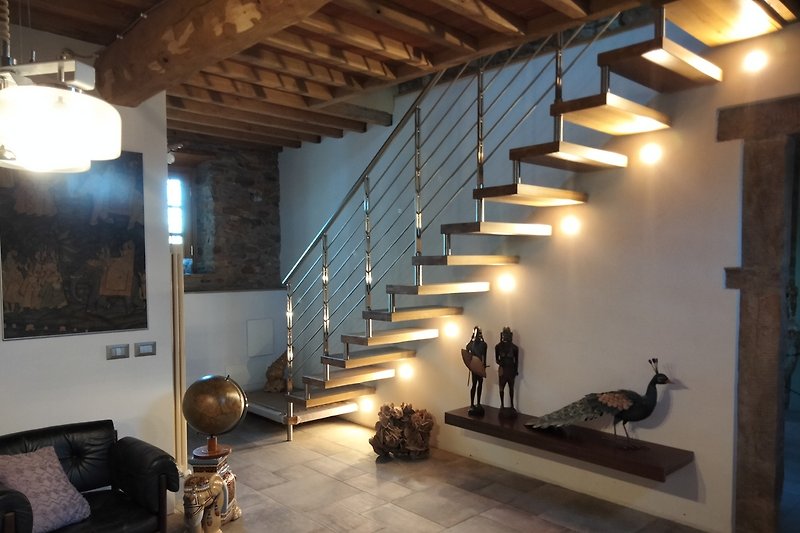 Stilvolles Wohnzimmer mit Steinboden,Kunstwerken und hellem Tageslicht.