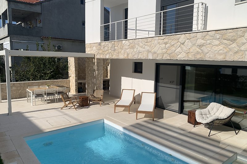 A luxurious property with a swimming pool and stylish outdoor furniture.