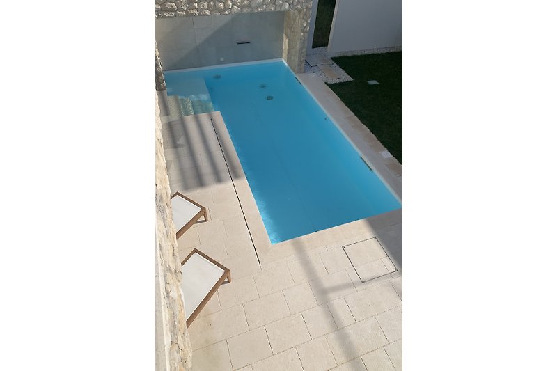 A private pool surrounded by the white stone tiles