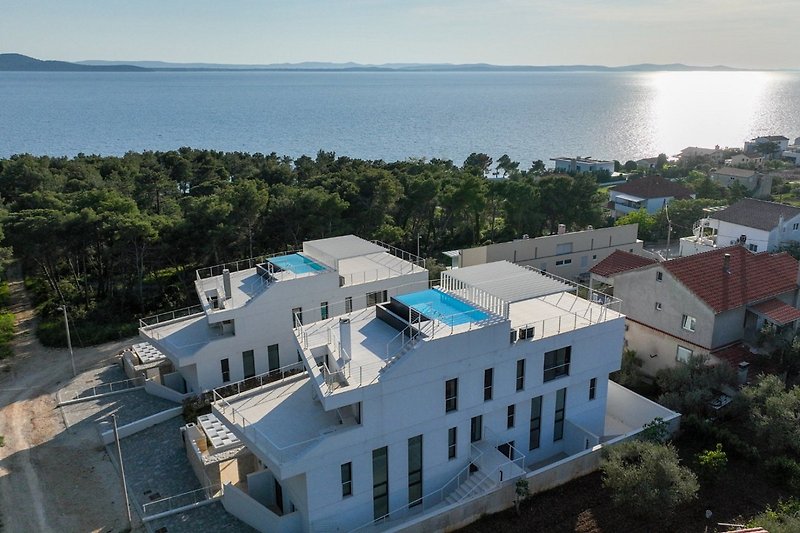 A stunning lakeside property with a panoramic view of the azure water and urban design.