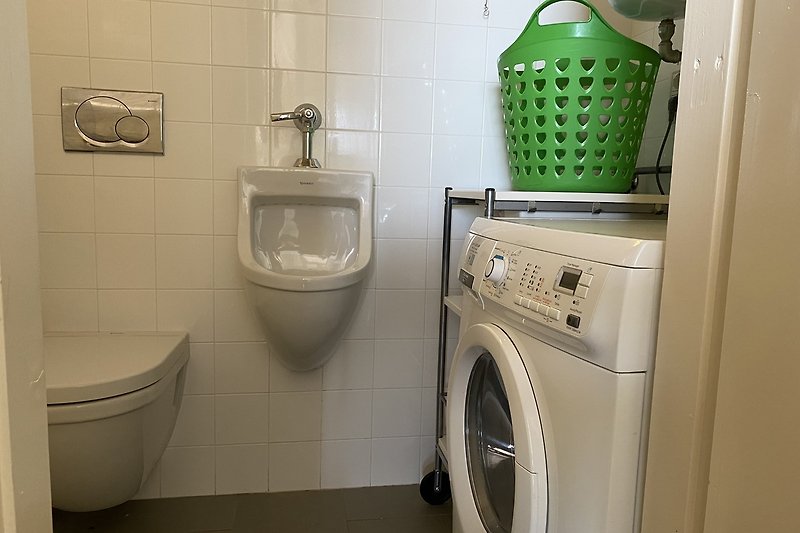 A modern laundry room with a washing machine and clothes dryer.