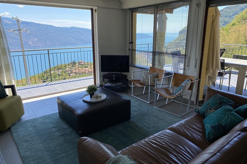 Stylish living room with comfortable furniture and a stunning view of the water and mountains.
