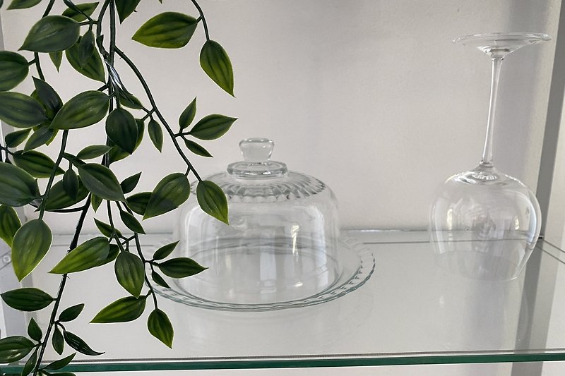 A refreshing drinkware with a glass bottle and liquid on a transparent shelf.