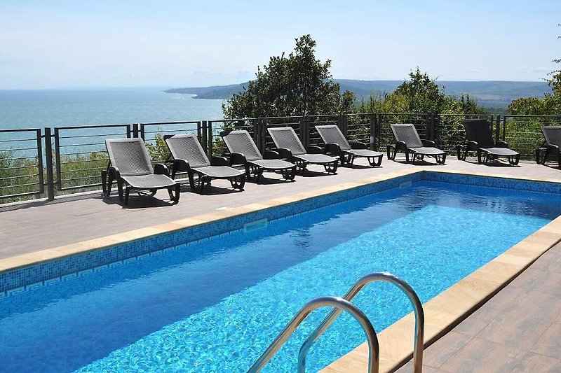 Relax by the poolside with view towards the sea