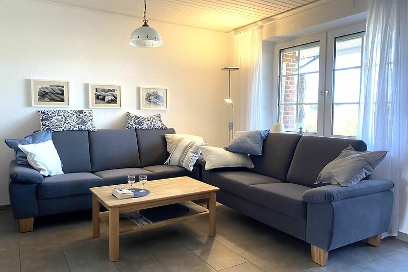 Gemütliches Wohnzimmer mit blauer Couch, Holzmöbeln und stilvoller Beleuchtung.