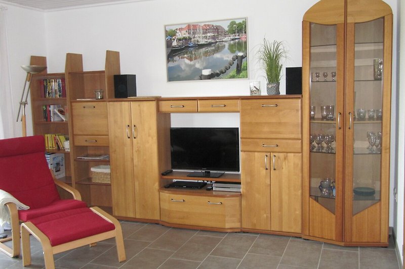 Gemütliches Wohnzimmer mit Holzmöbeln und Unterhaltungsecke.