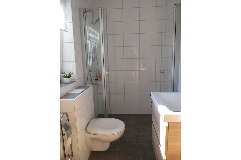 Schönes Badezimmer mit lila Spiegel, Toilette und Waschbecken.
