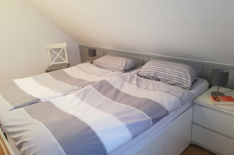 Gemütliches Schlafzimmer mit bequemem Bett und stilvollem Holzmöbel-Design.