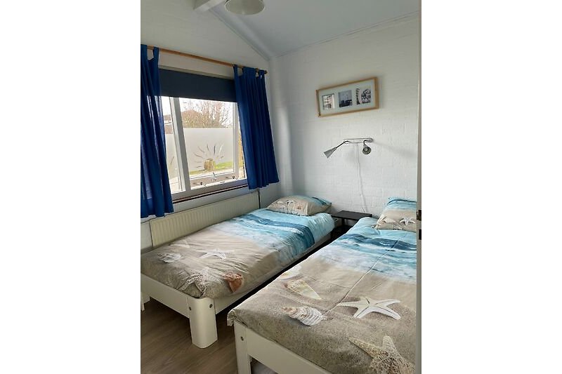 slaapkamer met twee éénpersoonsbedden en kledingkast