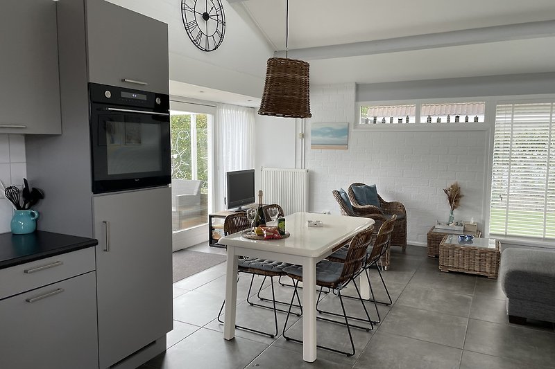 Moderne keuken met grijze kasten, houten aanrecht en stijlvolle meubels.