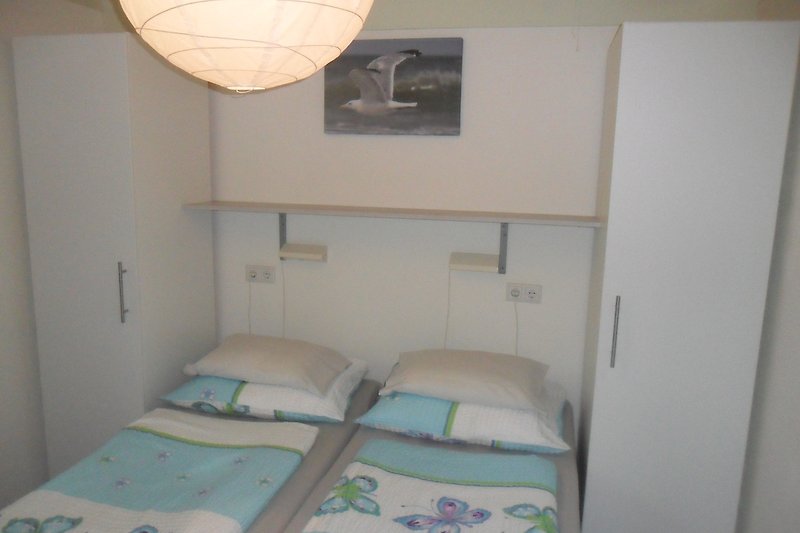 Ein gemütliches Schlafzimmer mit Betten, Kissen und Lampe.