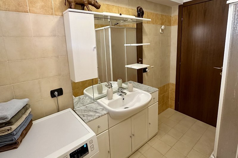 Ein modernes Badezimmer mit Spiegel, Waschbecken und Armatur.