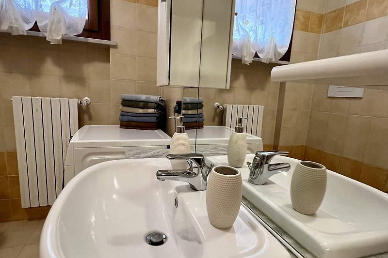 Ein stilvolles Badezimmer mit Spiegel, Waschbecken und Geschirr.