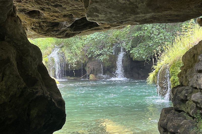 Eine atemberaubende Landschaft mit Wasserfall, Fluss und üppiger Vegetation Cascade de Saint Maurice Navacelles