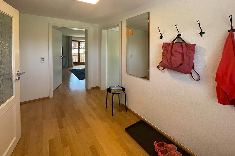 Moderne Wohnung mit stilvollem Holzboden und Kunst an der Wand.
