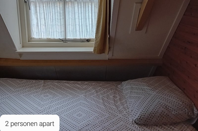 Mooie slaapkamer met houten vloer en comfortabel bed.