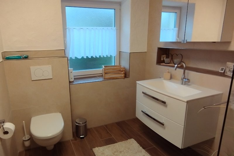 Schönes Badezimmer mit Waschbecken, Spiegel und Toilette.