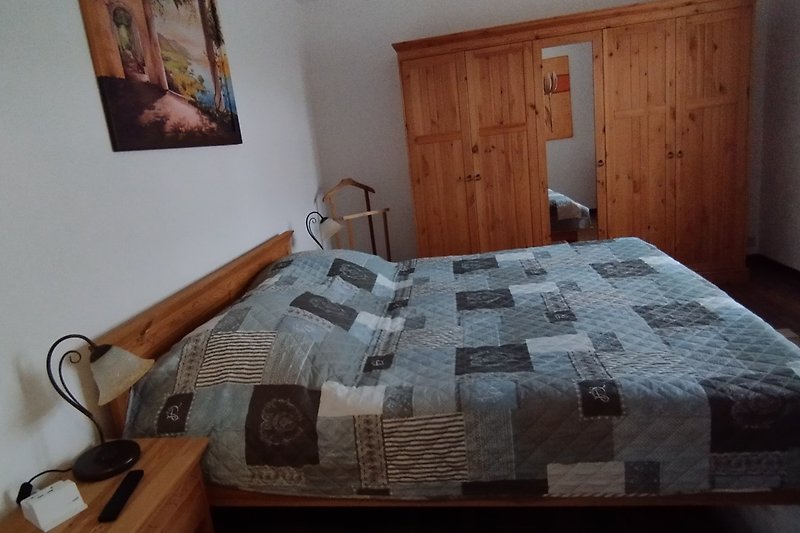 Gemütliches Schlafzimmer mit bequemem Bett, Holzboden und stilvoller Inneneinrichtung