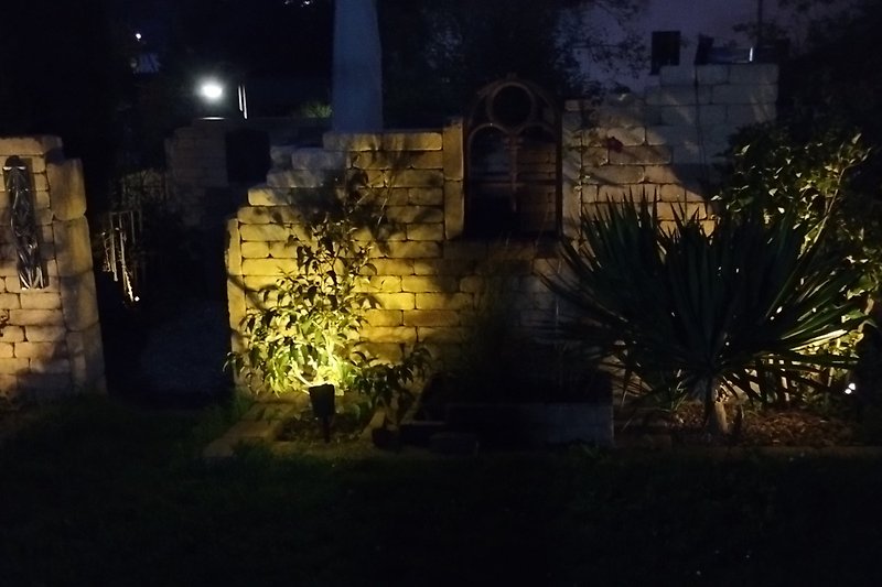 Gartenbereich mit nächtlicher Beleuchtung und historischem Charme