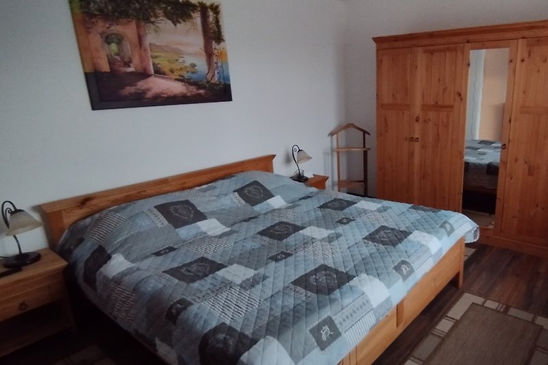 Gemütliches Schlafzimmer mit stilvollem Holzbett und schöner Inneneinrichtung