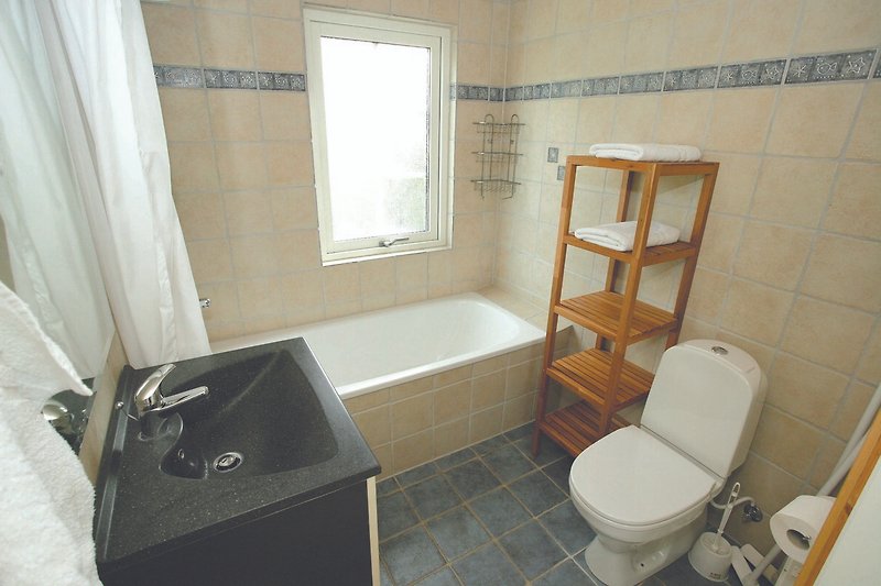 Gemütliches Badezimmer mit Badewanne und Fenster