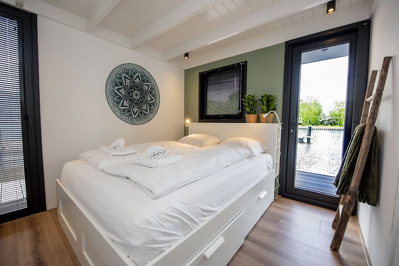 Een comfortabele slaapkamer met houten meubels en een groot raam.