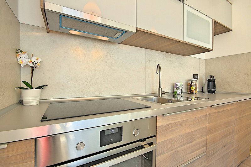A modern kitchen with sleek cabinetry, countertop, and kitchen appliances.