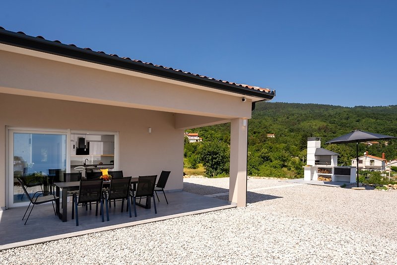 Einladende Terrasse mit Tisch, Stühlen und Blick auf die Landschaft - perfekt für einen erholsamen Urlaub.