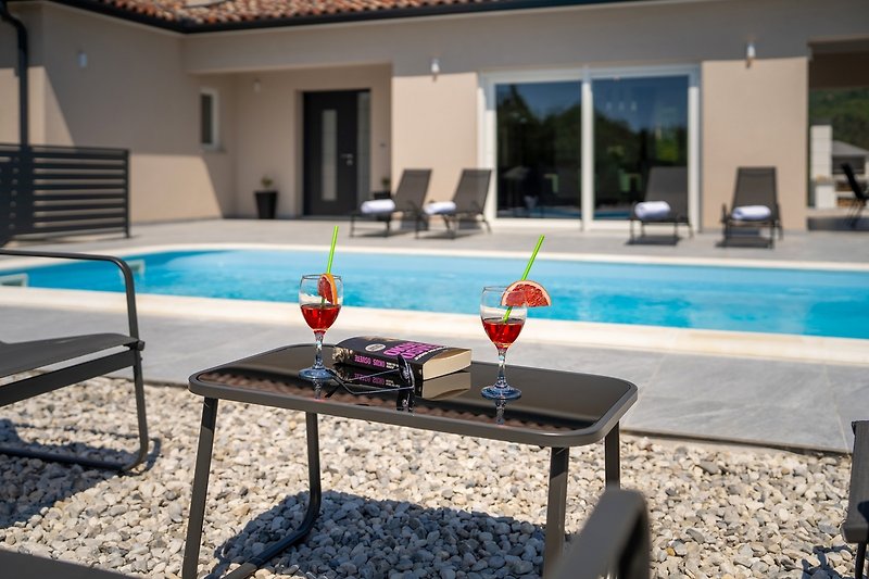 Schwimmbad, Möbel, Licht und Pflanzen - perfekt für einen entspannten Urlaub.