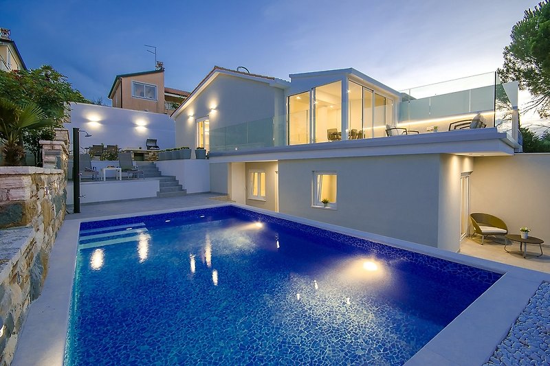 A luxurious seaside property with a stunning swimming pool and breathtaking views.