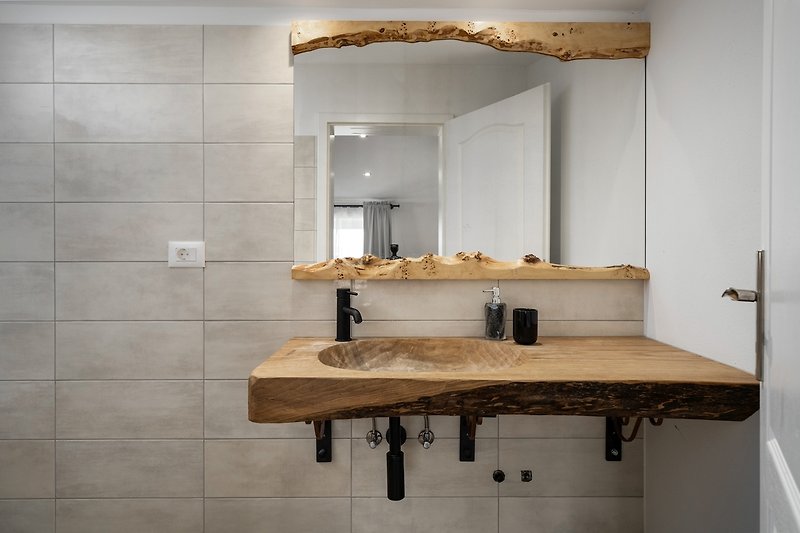 A stylish bathroom with a sleek sink, mirror, and elegant fixtures.