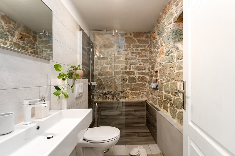 A modern bathroom with a sleek sink, mirror, and shower.