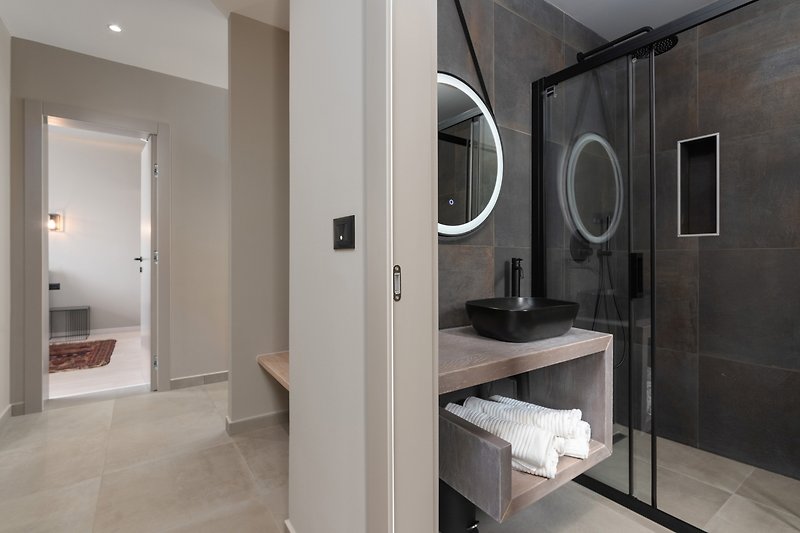 Schönes Badezimmer mit Spiegel, Waschbecken und Holzboden.