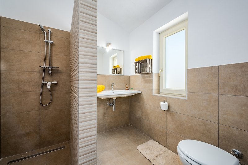 Schönes Badezimmer mit Spiegel, Waschbecken und stilvoller Beleuchtung.