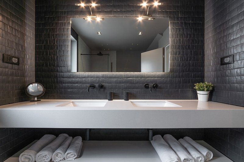 Schönes Badezimmer mit Spiegel, Waschbecken und Holzboden.