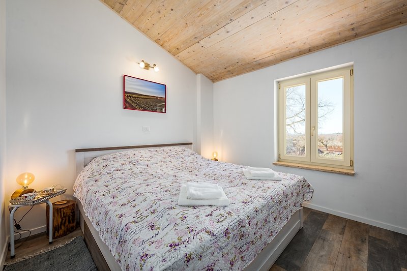 Gemütliches Schlafzimmer mit Holzmöbeln und Fensterblick.