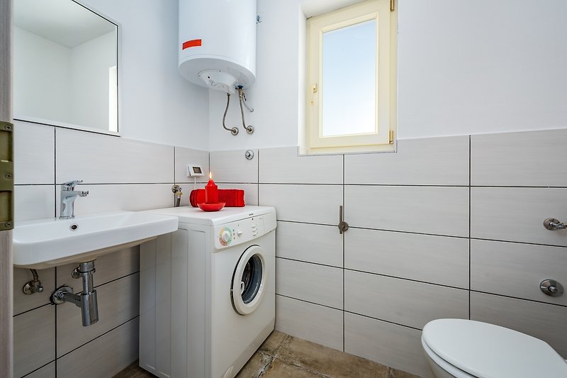 Schönes Badezimmer mit Spiegel, Waschbecken und Schränken.