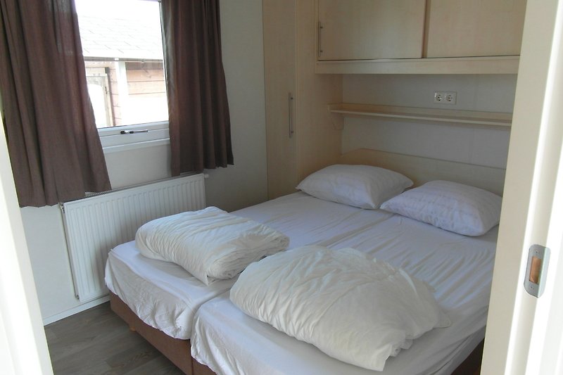 Gemütliches Schlafzimmer mit Holzmöbeln und gemütlichem Bett.