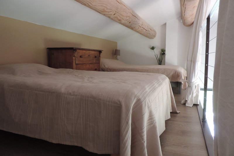 Gemütliches Schlafzimmer mit Holzbett, bequemen Kissen und stilvoller Einrichtung.
