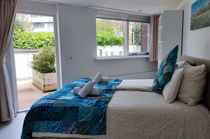Ein stilvolles Wohnzimmer mit bequemer Couch, Fenster und Pflanze.