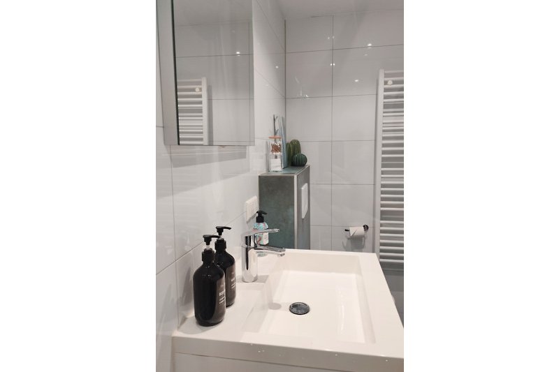 Elegantes Badezimmer mit Spiegel, Waschbecken und Fliesen.