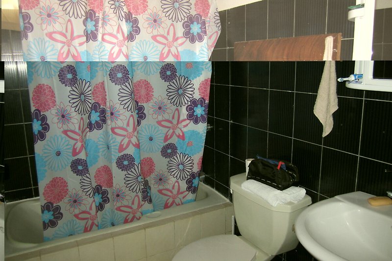 Badezimmer mit lila Akzenten, Keramik und Kunst.