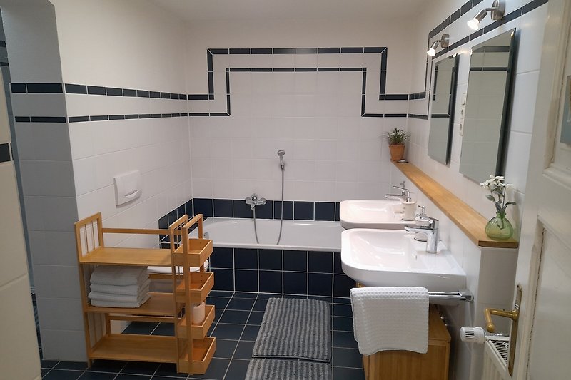 Schönes Badezimmer mit zwei Waschbecken und Spiegel, übergroße Badewanne und WC im Erdgeschoss