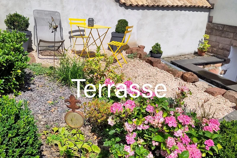 Blühender Garten mit Sitzbereich und üppiger Pflanzenvielfalt, ausschließlich für unsere Gäste