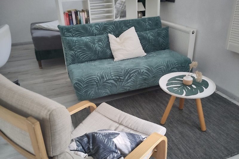 Gemütliches Wohnzimmer mit Design Sofa, Holztisch und Lesesessel