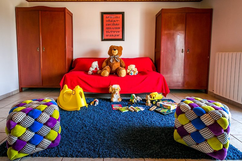 Udobna soba s drvenim krevetom, mekanim jastucima i igračkama.