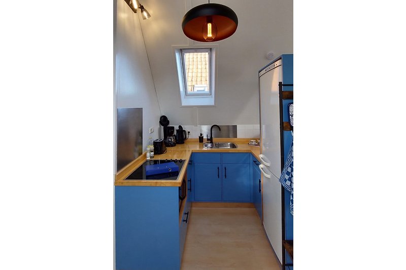 Prachtige keuken met houten kasten, aanrechtblad en moderne verlichting.