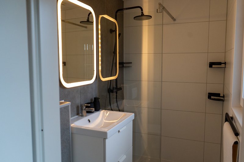 Schönes Badezimmer mit Spiegel, Waschbecken und stilvoller Armatur.