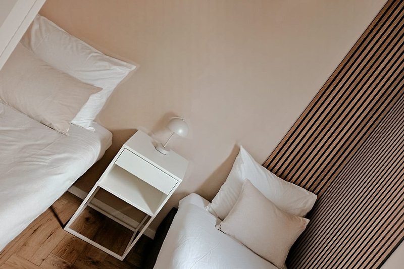 Stijlvolle slaapkamer met comfortabel bed, zachte kussens en elegante verlichting.